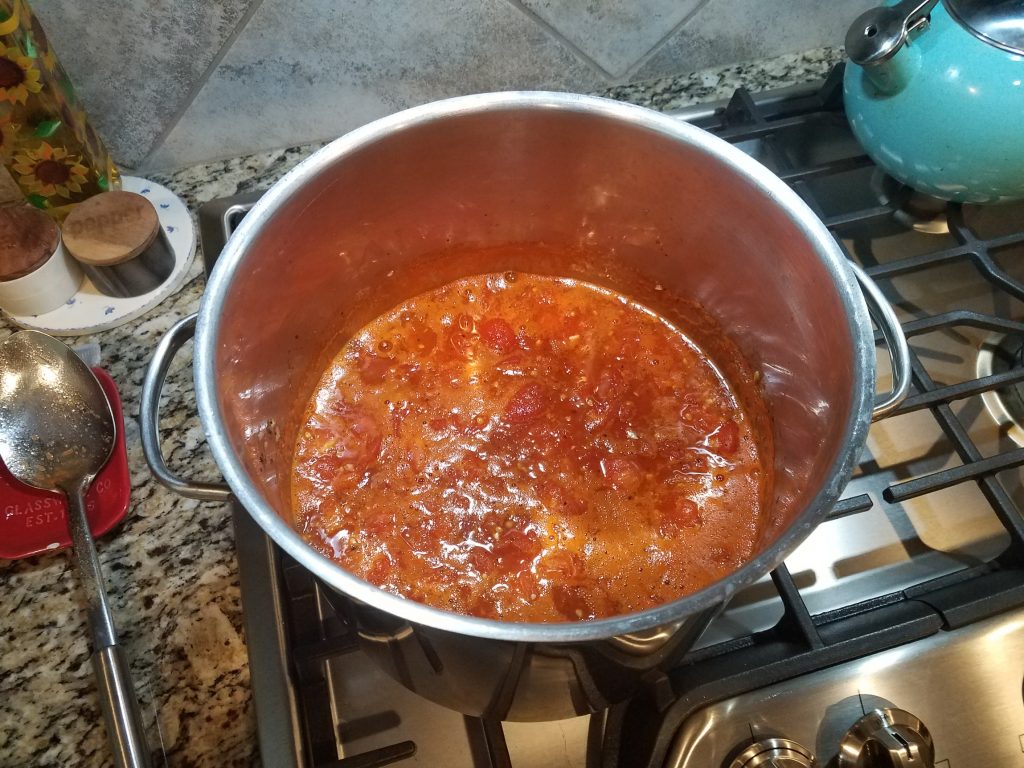 Sauce in stainless steel stockpot simmering.